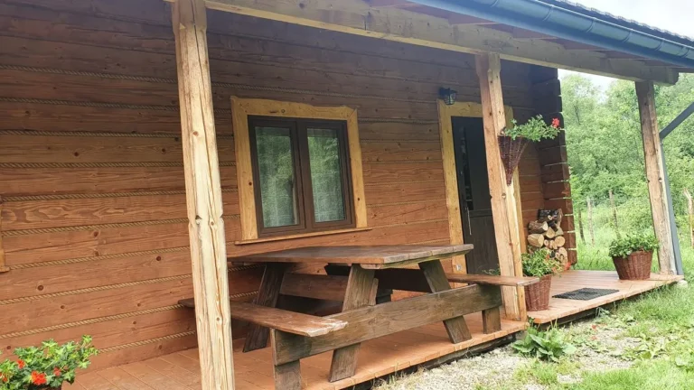 Domek LYNX od frontu, z ławą przed wejściem — domek parterowy LYNX, domki W Dolinie Sanu w Zatwarnicy (Bieszczady)