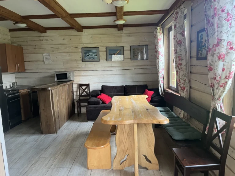 Salon z drewnianym stołem — domek parterowy LYNX, domki W Dolinie Sanu w Zatwarnicy (Bieszczady)